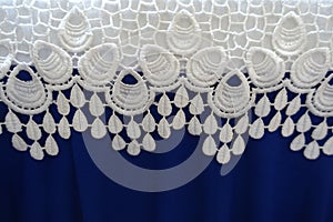 White lacy fabric over electric blue fabric