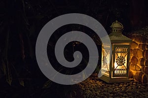 White lamp with burning flame on street steps. Lantern in the evening garden in Asia. Romantic decoration. Outdoor illumination.