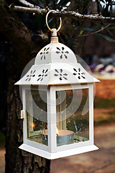 White lamp and lighted candle, as decoration in cemetery photo