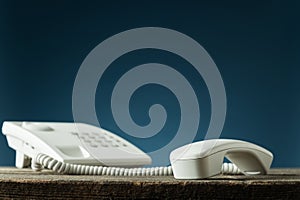 White landline telephone with handset off the hook