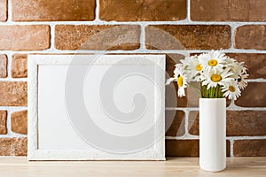 White landscape frame mockup with daisy bouquet in styled vase