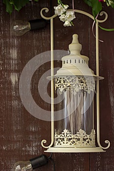 White lantern on browm wooden background or fence.