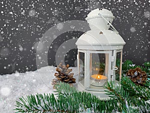 White lantern glowing on a snowy christmas night. Festive snowy background.