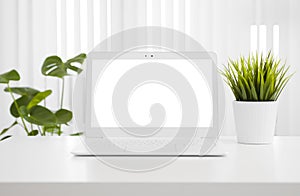 White laptop computer mockup with blank screen on office table