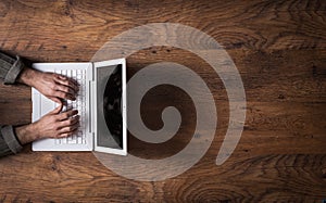 White laptop on a dark wooden desktop