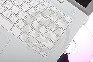 White laptop with dvd disk in slot. Isolated.