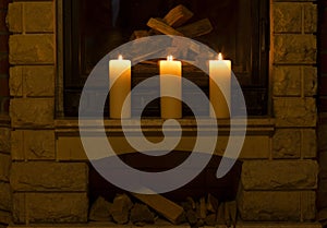 White large candles standing on the fireplace.