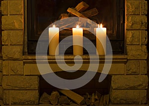 White large candles standing on the fireplace.