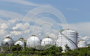 White large storage tanks under a blue sky.