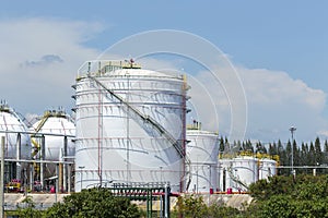 White large storage tanks under a blue sky.