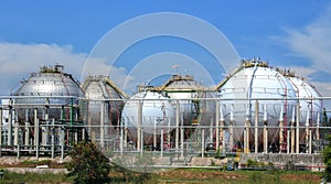 White large storage tanks under a blue sky.