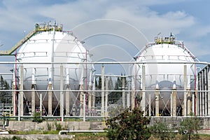 White large storage tanks under a blue sky.