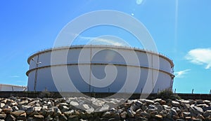 White large storage tanks under a blue sky.