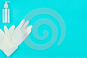 White latex gloves and hand sanitizer gel on blue background.