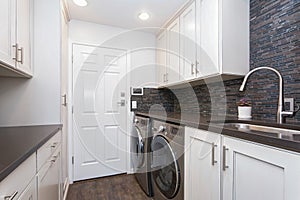 White laundry room boasts white shaker cabinets photo