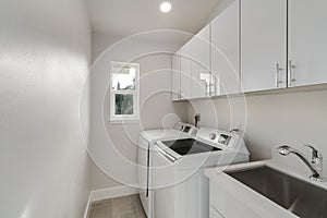 White laundry room features washer and dryer