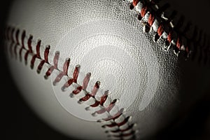 A white leather baseball on a black background