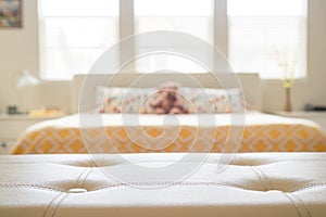 White leather empty bench in front of blurred bedroom