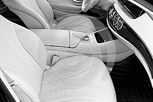 White leather interior of the luxury modern car. Leather comfortable white seats and multimedia. Steering wheel and dashboard. Aut