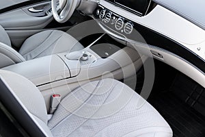 White leather interior of the luxury modern car. Leather comfortable white seats and multimedia. Steering wheel and dashboard.