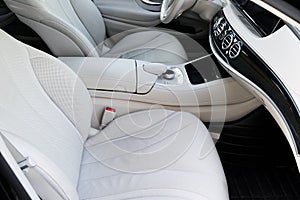 White leather interior of the luxury modern car. Leather comfortable white seats and multimedia. Steering wheel and dashboard.