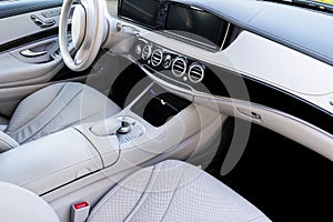 White leather interior of the luxury modern car. Leather comfortable white seats and multimedia. Steering wheel and dashboard.