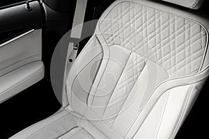 White leather interior of the luxury modern car. Perforated white leather comfortable seats with stitching. Modern car interior de photo