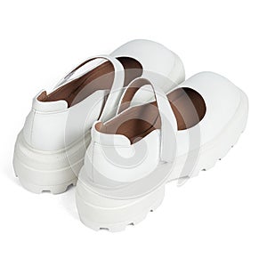 White leather women's shoes on a strap with a thick sole on a white background