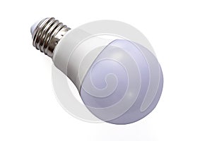 A white LED lamp with an E27 base lies on a white insulated background