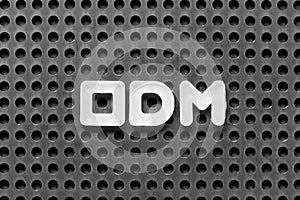 White letter in word ODM (Abbreviation of Original design manufacturer) on black pegboard background