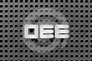 White letter in word OEE abbreviation of overall equipment effectiveness on black pegboard background