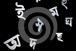 The white letters of the Bengali alphabet are Being visible in the black background.