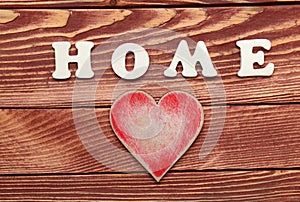 White letters with word HOME and heart on wooden background