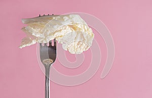 White lettuce leaf on a fork on a green background