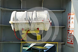 White life raft without hydrostatic release secured in forward station of container ship.