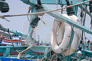 white life ring hanged against green mint pole of wooden fishing boat
