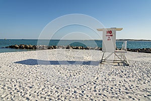 White lifeguard tower with painted red No Lifeguard On Duty lettering sign on the door- Destin, FL