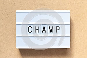 White light box with word champ on wood background