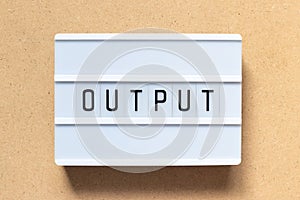 White light box with word output on wood background