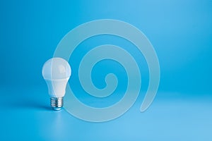 White light bulb on blue background in pastel colors. Bright idea concept