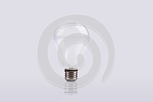 A White light bulb in front of a grey background