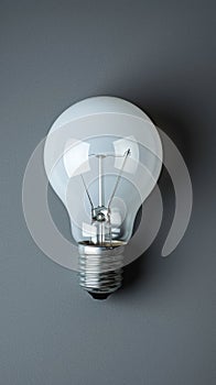 White Light Bulb Illuminating Gray Wall