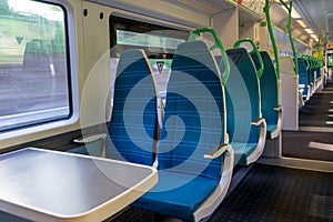 White light panoramic view interior of a high speed electric modern train with blue seats