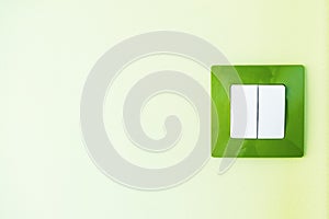 White light switch on a green wall