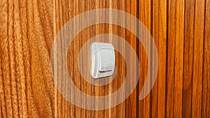 White light switch mounted on wooden wall interior