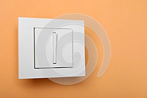 White light switch on orange background, space for text