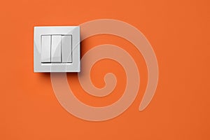White light switch on orange background. Space for text