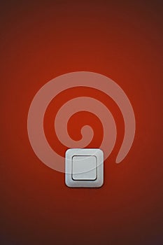 White light switch on a red wall