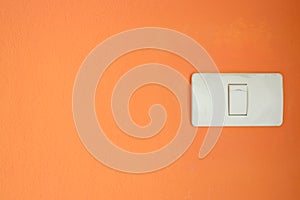 White light switch, turn on or turn off the lights on orange wall.