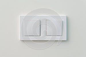 White light switch on the wall. Turn on or turn off the lights. Wall-mounted white double light switch